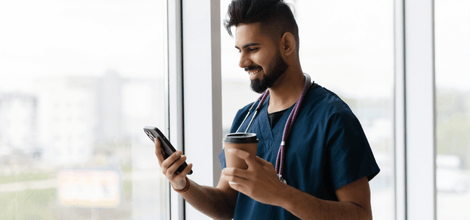 young doctor smiling at mobile